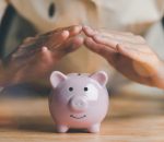 A man represents protection and protection of safety of the piggy bank ,Insurance management planning ,health care and finance ,property and family risk reduction,life and property protection planning